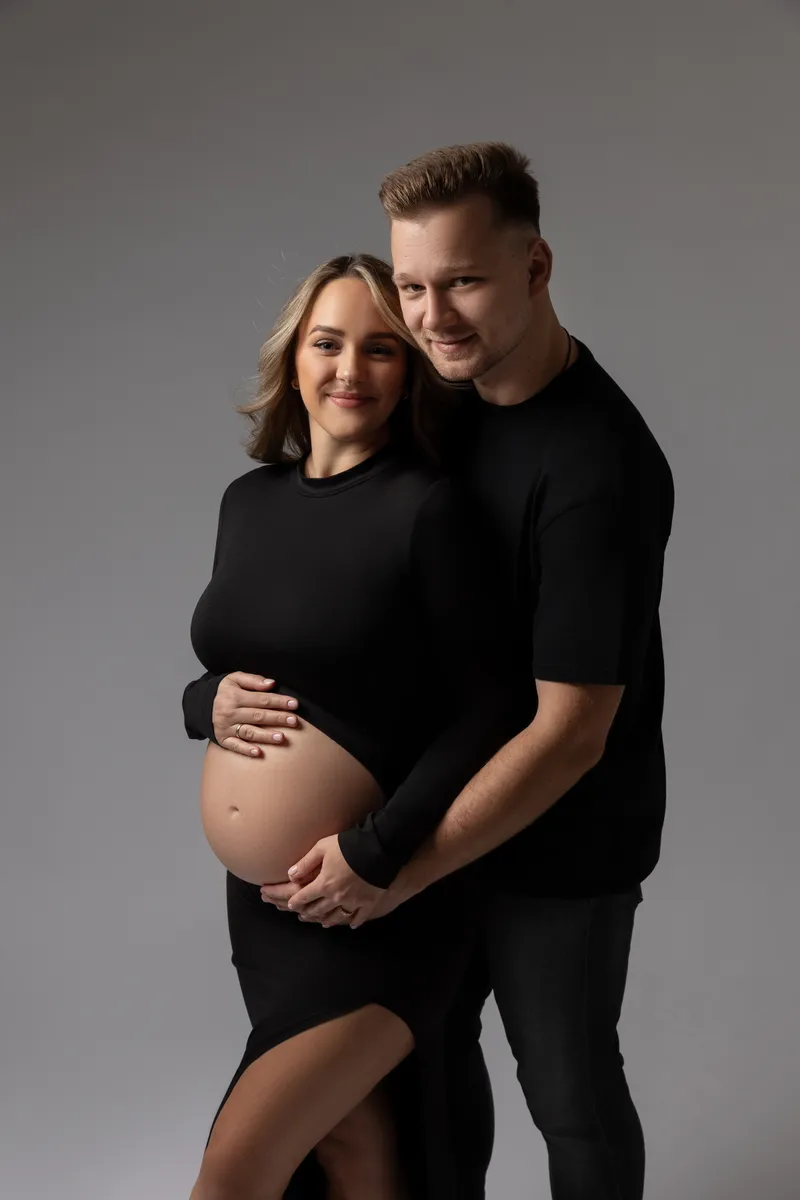Ein Paar in einem Studio, das die Schwangerschaft feiert.